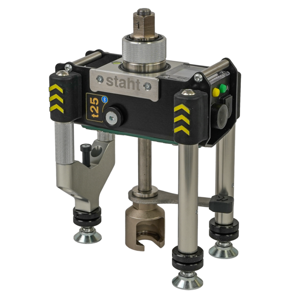A Staht industrial mechanical clamp or fixture component with a black and silver housing, yellow chevron markings, and four adjustable metal legs with locking nuts, shown on a plain white background.